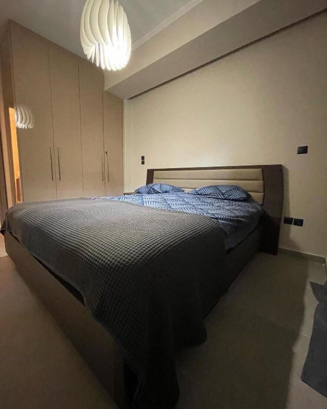 Una camera da letto con un letto, un armadio e una lampada a sospensione.