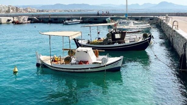 A marina with several boats docked, clear blue water, and a cityscape in the background. - Sehr Schöne und Moderne Ferienwohnung Lighthouse (Loutraki)