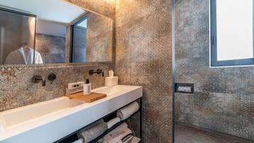 Un bagno moderno con un lavandino capiente, uno specchio e un porta asciugamani.