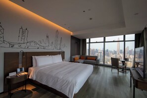 A modern hotel room with a large bed, a desk, and a view of the city skyline. - UrCove by Hyatt Shenzhen Bay Futian Port (Shenzhen)