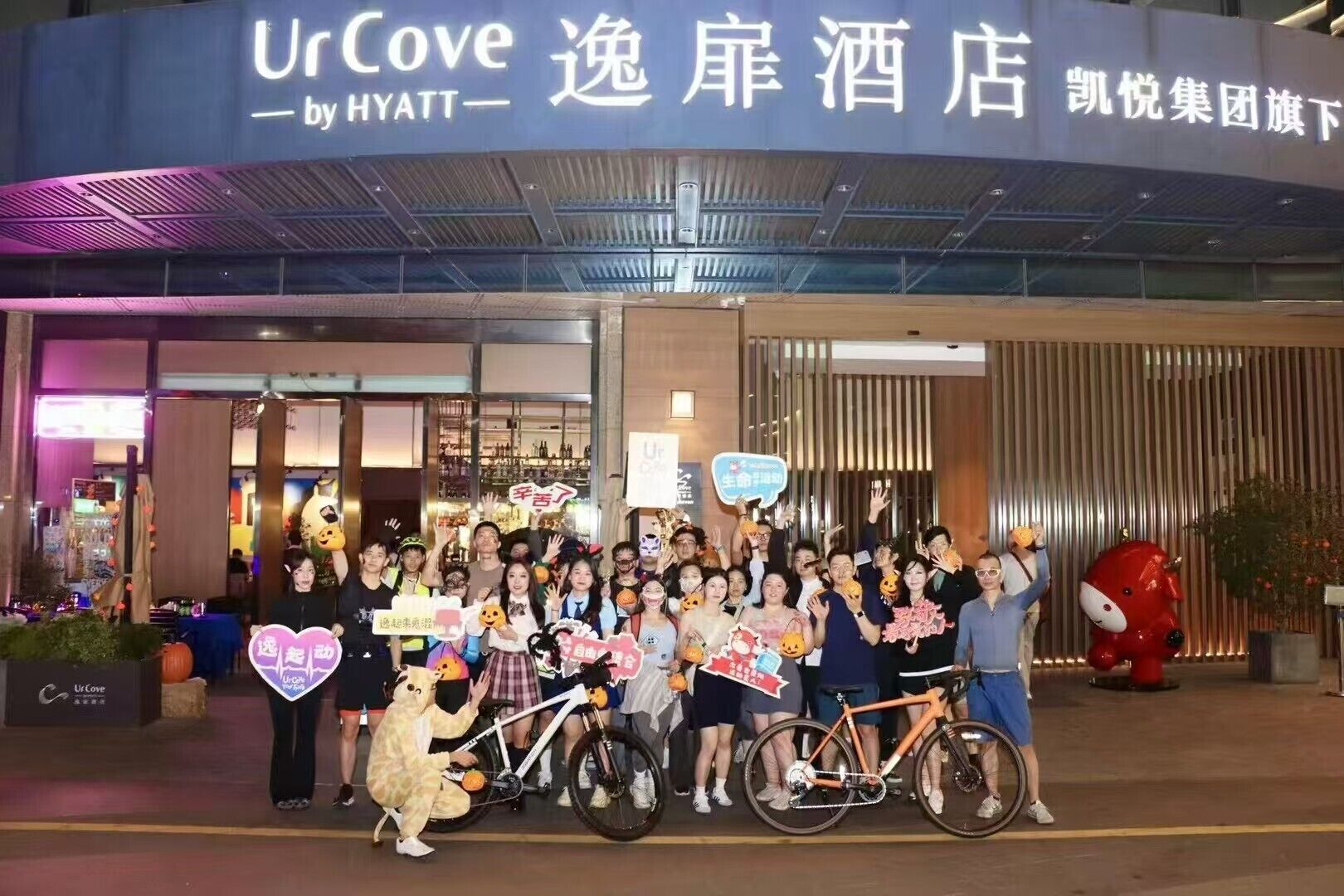 A group of people outside a hotel with a sign that reads 'UrCove by HYATT.'
