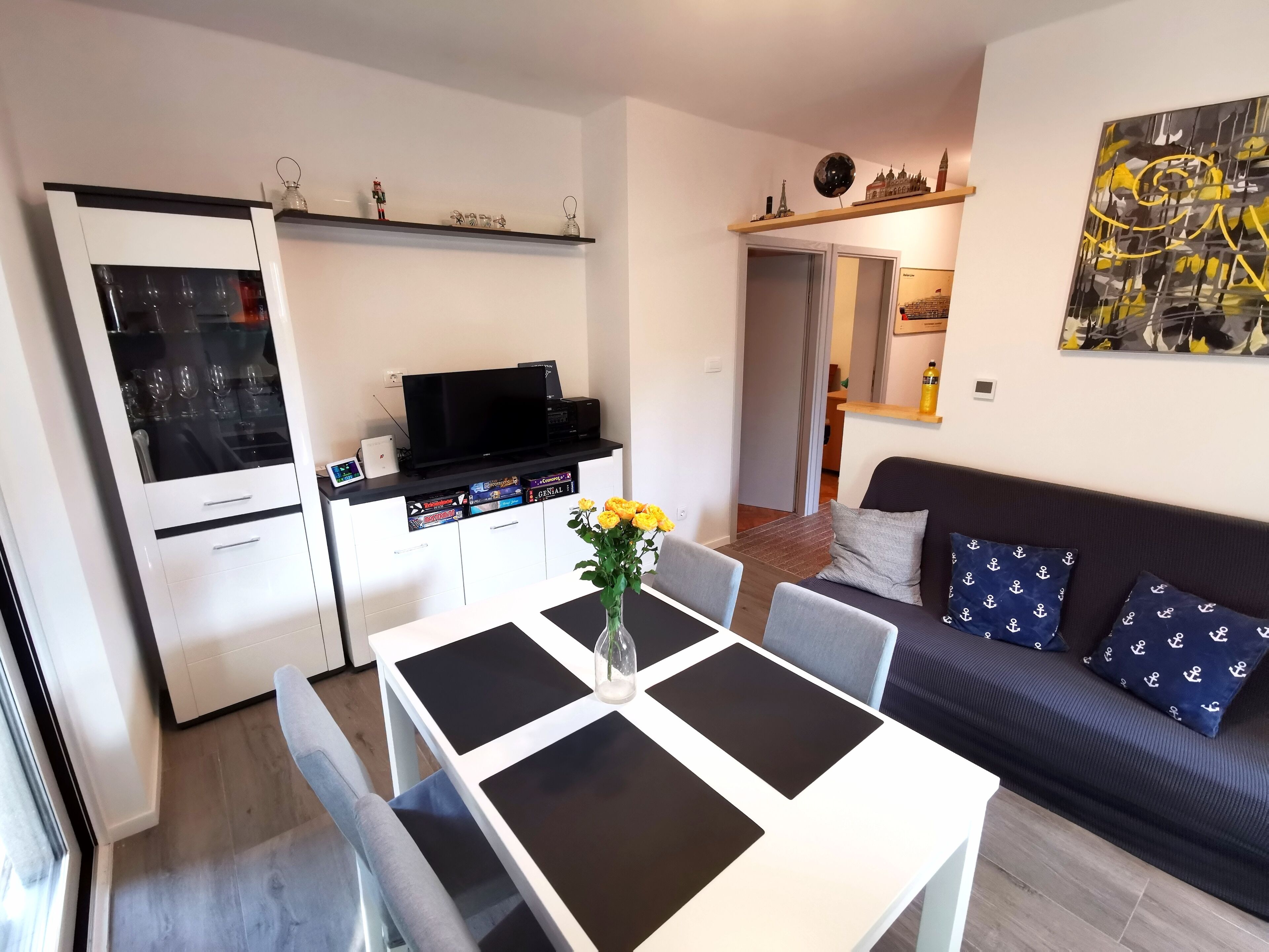A modern living space with a dining area, kitchen, and seating area.