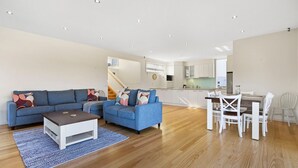 Una sala moderna con un conjunto de sofá, una mesa de centro y un comedor con sillas y una mesa.