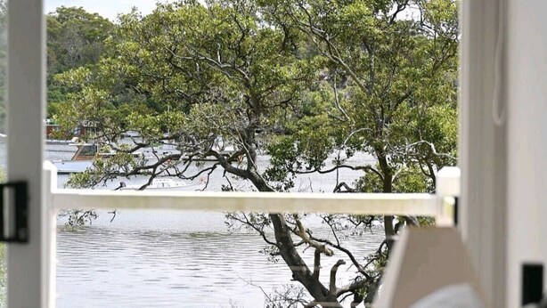 Una habitación con vista a un cuerpo de agua y árboles.