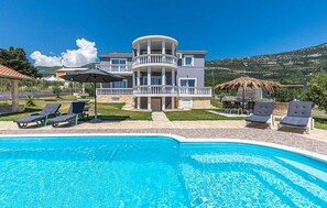 A two-story house with a pool, outdoor seating, and a view of the hills. - Villa with Private Pool (Rudine)