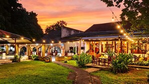 Un restaurante con terraza, zonas cubiertas y luces colgantes.