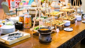 Una mesa de buffet con diversos alimentos y utensilios.