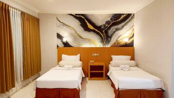 Ein Hotelzimmer mit zwei Betten, einem Holzkopfteil, einem Nachttisch und einer Marmorwand.