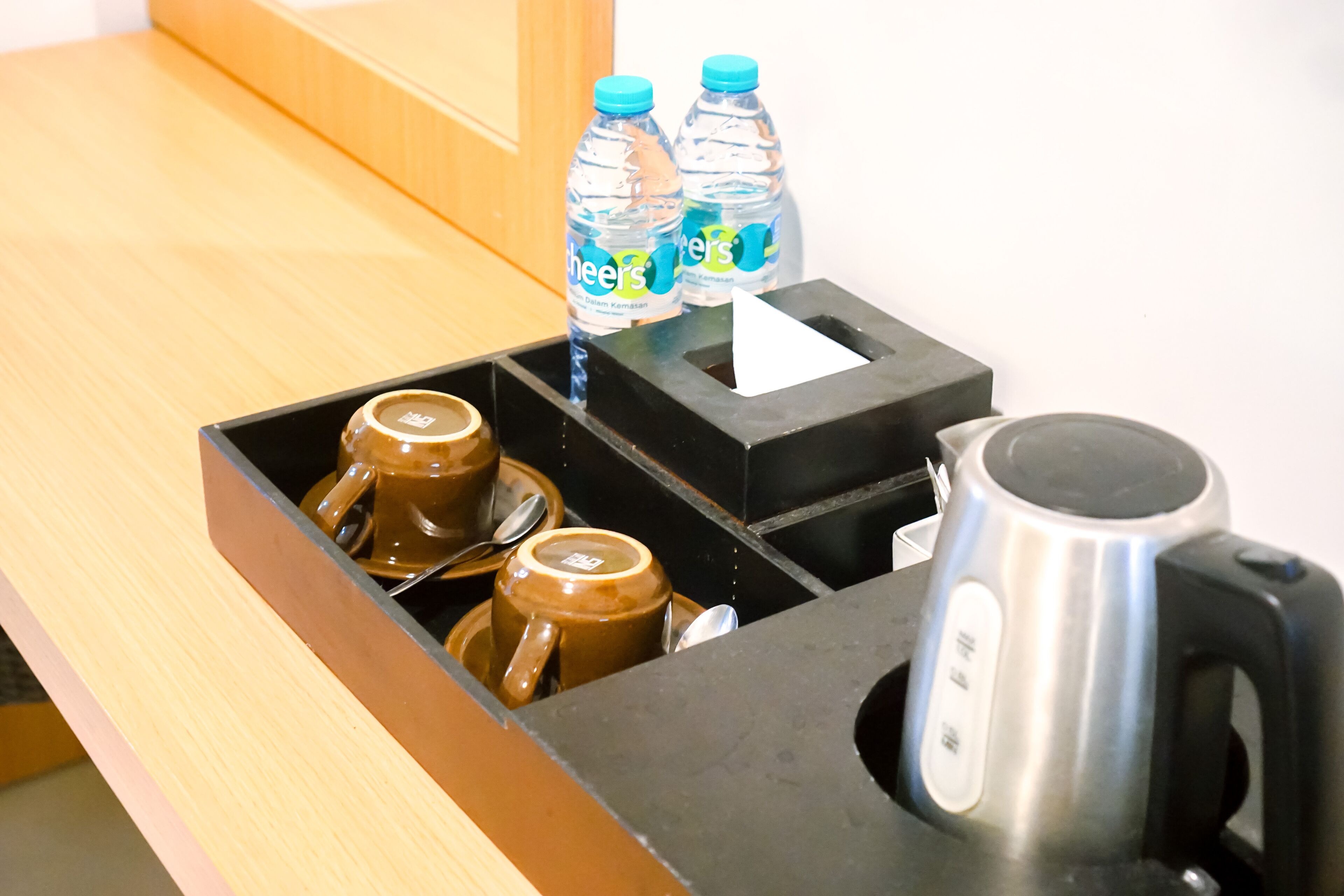 A kitchen counter with a coffee maker, two water bottles, and a tea kettle.