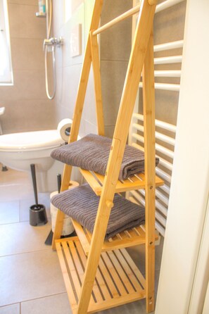 Eine kleine Holztreppe mit Handtüchern in einem Badezimmer.