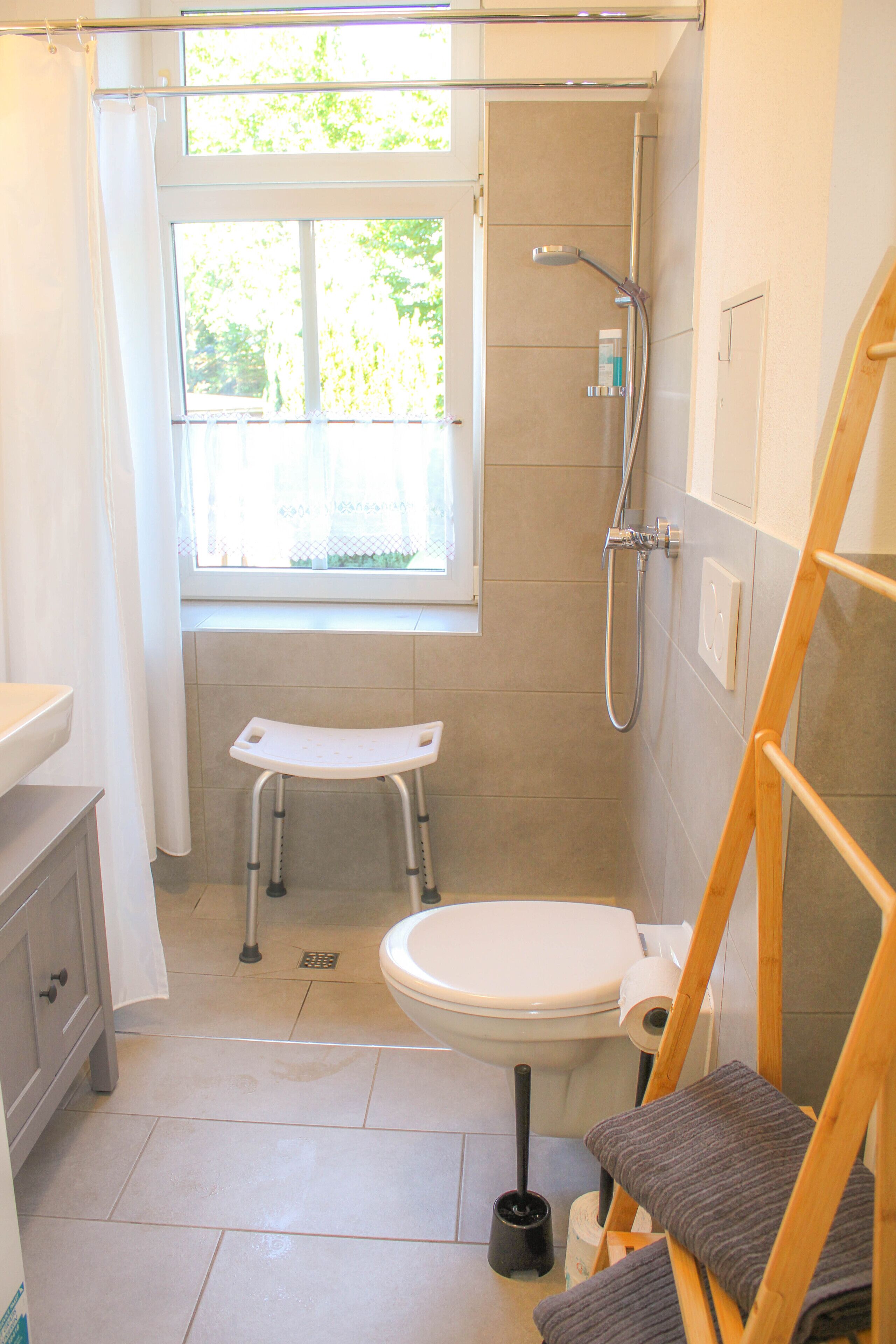 Ein kleines Badezimmer mit Dusche, Toilette und einer kleinen Trittstufe.