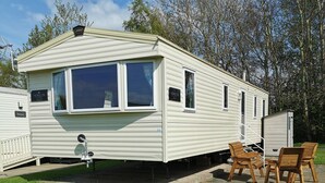 Une maison mobile dotée d’un patio, d’une petite terrasse et d’une enseigne indiquant le nom « HORIZON ».