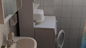 Un baño pequeño con lavamanos, inodoro y espejo.