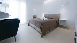 A modern bedroom with a bed, bedside tables, a desk, and a chair. - Maruzza Home 101 (Favignana)