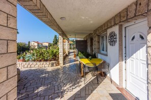 Relax in a serene outdoor space with a stone-paved patio, seating area, and potted plants.