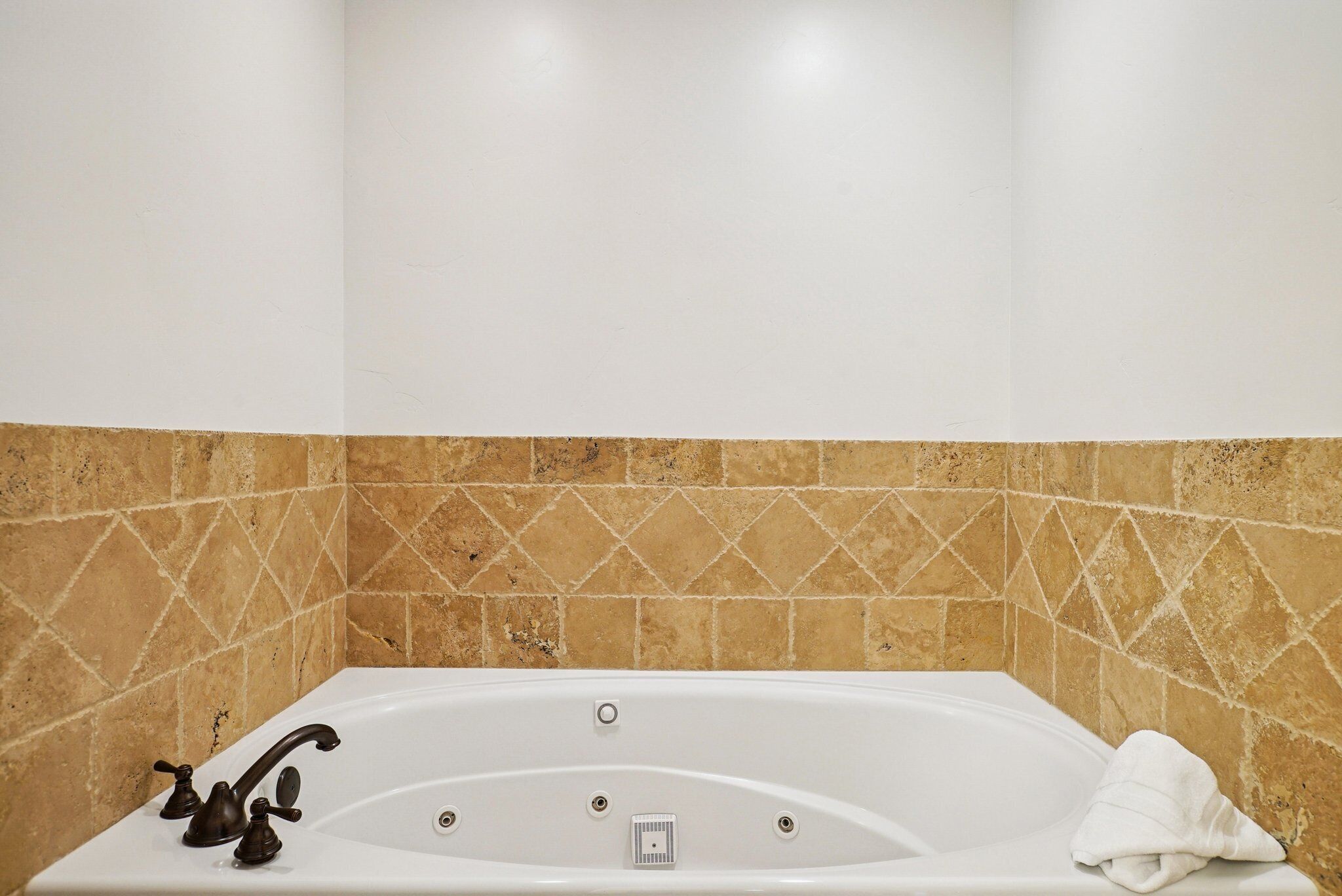 Une salle de bain avec une baignoire, une serviette et un pommeau de douche.