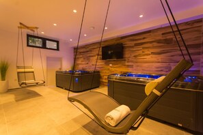 Relax in a serene spa room with two hot tubs and a flat-screen TV.