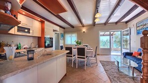 Enjoy meals in the spacious dining area with a glass table and comfortable seating.