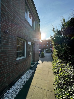 A brick building with a clear sky and sunlight.