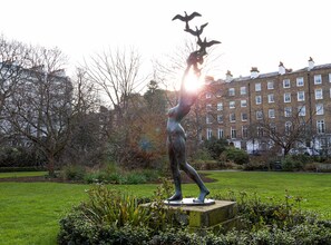 A statue in a park with a building in the background. - Beaverbrook Town House (London)