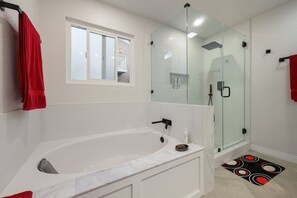 A modern bathroom with a large bathtub, a glass-enclosed shower, and a small window. - Modern Dream Home - Fire Pit, Grill, Large Yard & AC (Encinitas)