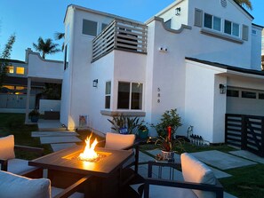 A modern two-story house with a patio area featuring a fire pit and outdoor seating. - Modern Dream Home - Fire Pit, Grill, Large Yard & AC (Encinitas)