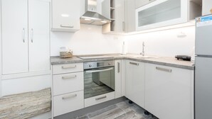 A modern kitchen with white cabinetry, a built-in oven, and a stainless steel range hood. - Centrally-located two-bedroom apartment w/sunny terrace Marina IV. (Split)