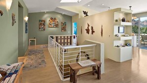 A spacious room with a high ceiling, a staircase, and a view of the outdoors. - Breathtaking Unblockable Red Rock Views, 3BD sleeps 7, West Sedona! (Sedona)