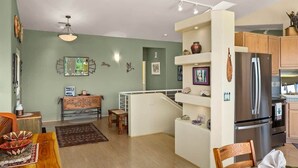 A modern kitchen with a refrigerator, wooden cabinets, and a dining area with a table and chairs. - Breathtaking Unblockable Red Rock Views, 3BD sleeps 7, West Sedona! (Sedona)