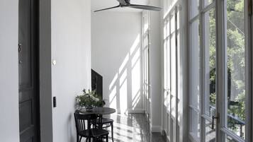 Passadís amb un paviment tipus alenç i grans finestres i ventiladors de sostre.