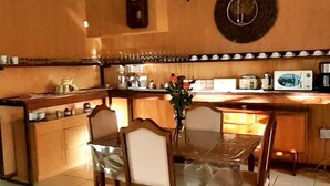 Una cocina con una mesa de comedor, sillas y diversos electrodomésticos.