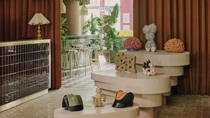 A room with a checkered floor, a metal cage, a lamp, a plant, a small table with shoes, and a decorative sculpture. - Ember Locke Kensington (London)