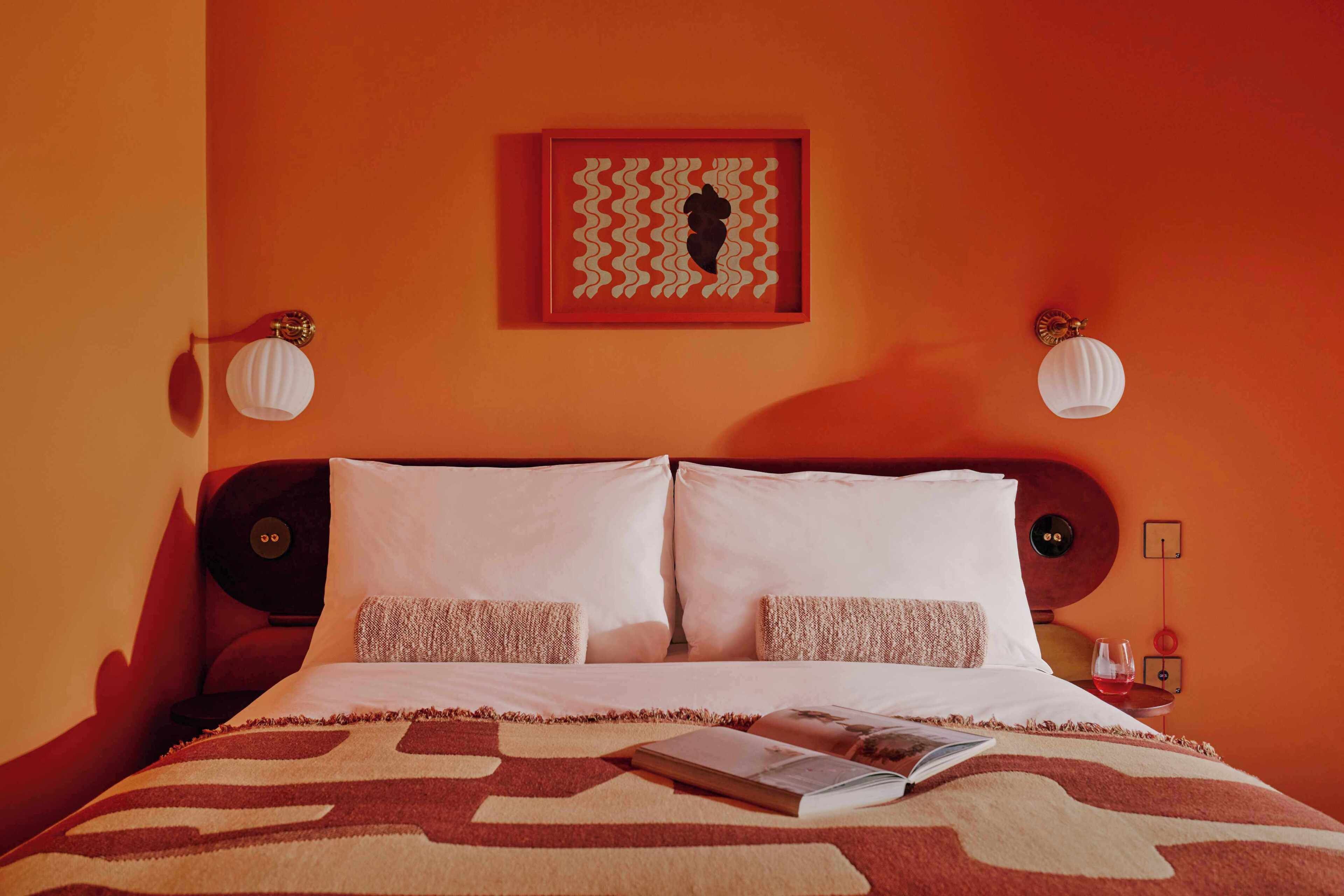 Ein Hotelzimmer mit einem Bett, zwei Nachttischen, einer Lampe und einem Bild über dem Bett.