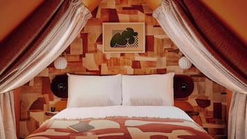A bedroom with a wooden headboard, a bed with white linens, two bedside tables, and a framed picture on the wall.