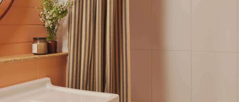 A bathroom with a white sink, a striped shower curtain, and a towel rack.