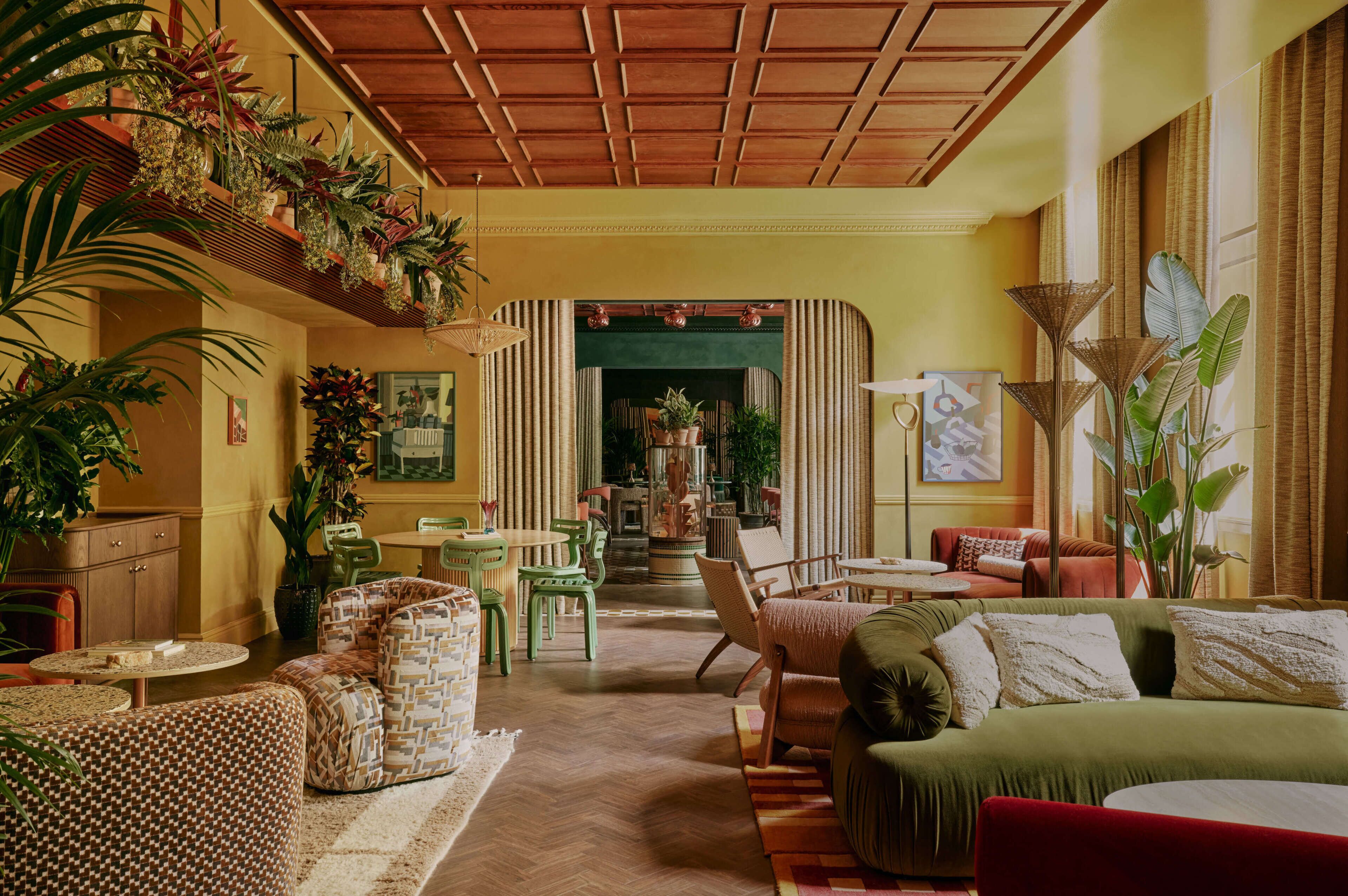 A spacious living room with a high ceiling, a fireplace, and multiple seating areas.
