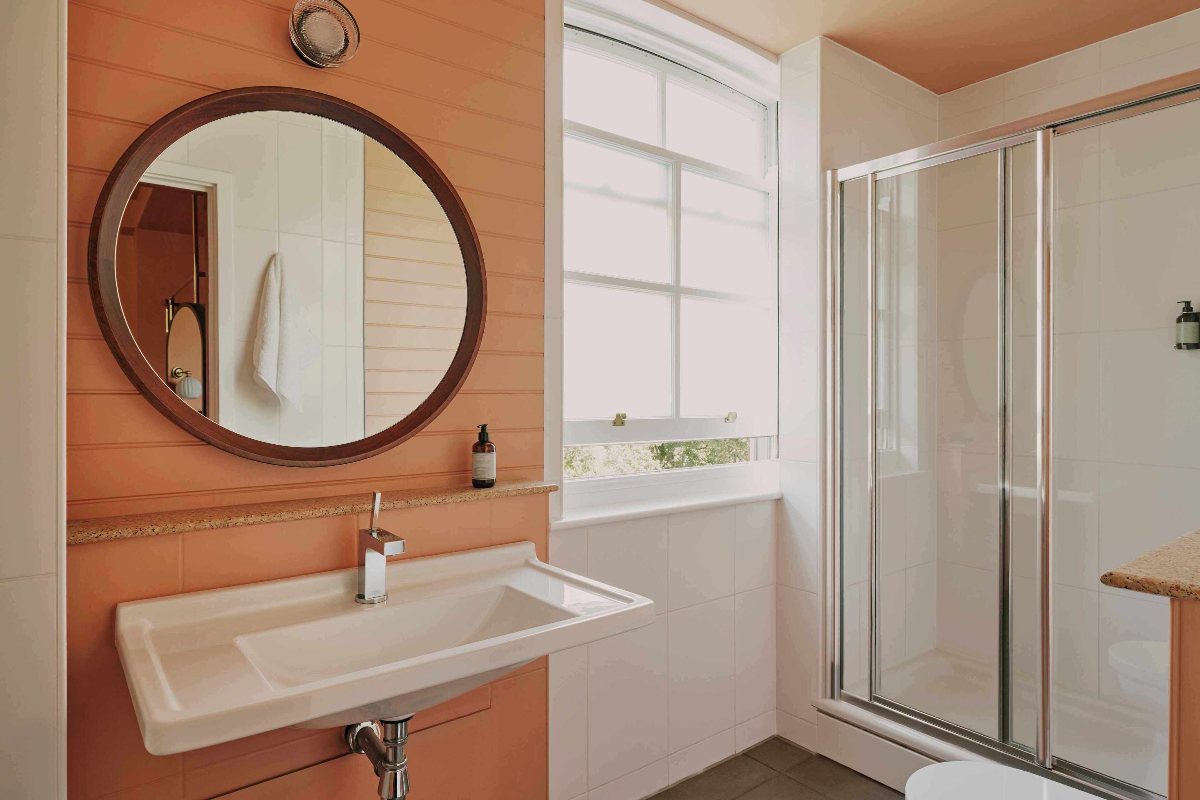A bathroom with a sink, mirror, and glass shower enclosure.