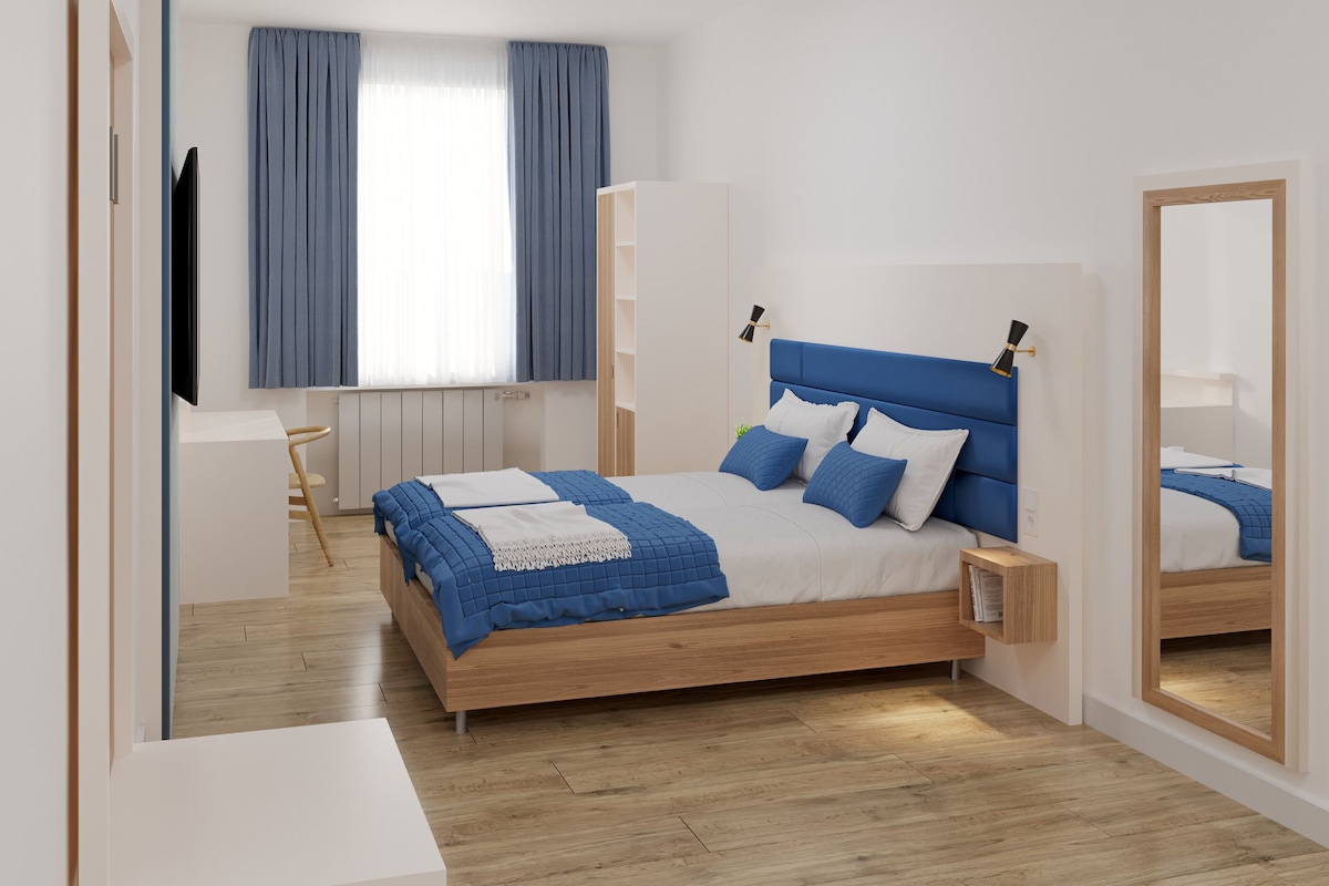Un dormitorio moderno con cama de madera, mesita de noche, armario empotrado y un espejo grande.