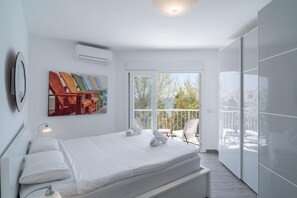 Enjoy a restful stay in this stylish room with a comfortable bed, wall-mounted air conditioning, and a large window offering a view of the outdoors.