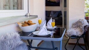 A breakfast setup with croissants, orange juice, and a bowl of cereal on a table. - Ferienwohnung Eden Apartments (Friedrichshafen)