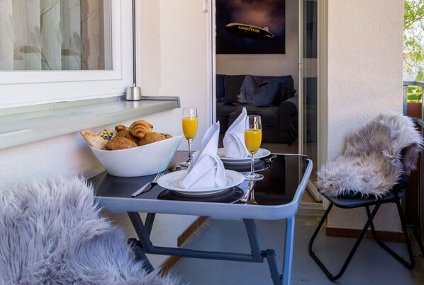 A breakfast setup with croissants, orange juice, and a bowl of cereal on a table.