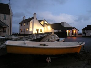 A row of boats parked near a building with a sign reading "Sundower's Terrace". - 'Raggleswood' - a seaside home on Friars Cliff, Mudeford (Christchurch)