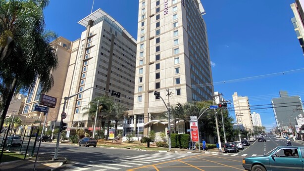 A hotel with a modern design, featuring a prominent vertical structure and multiple floors. - Smart Business Flat (Campinas)