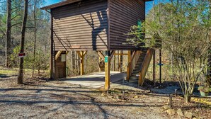 Eine Holzhütte mit Veranda, umgeben von Bäumen.