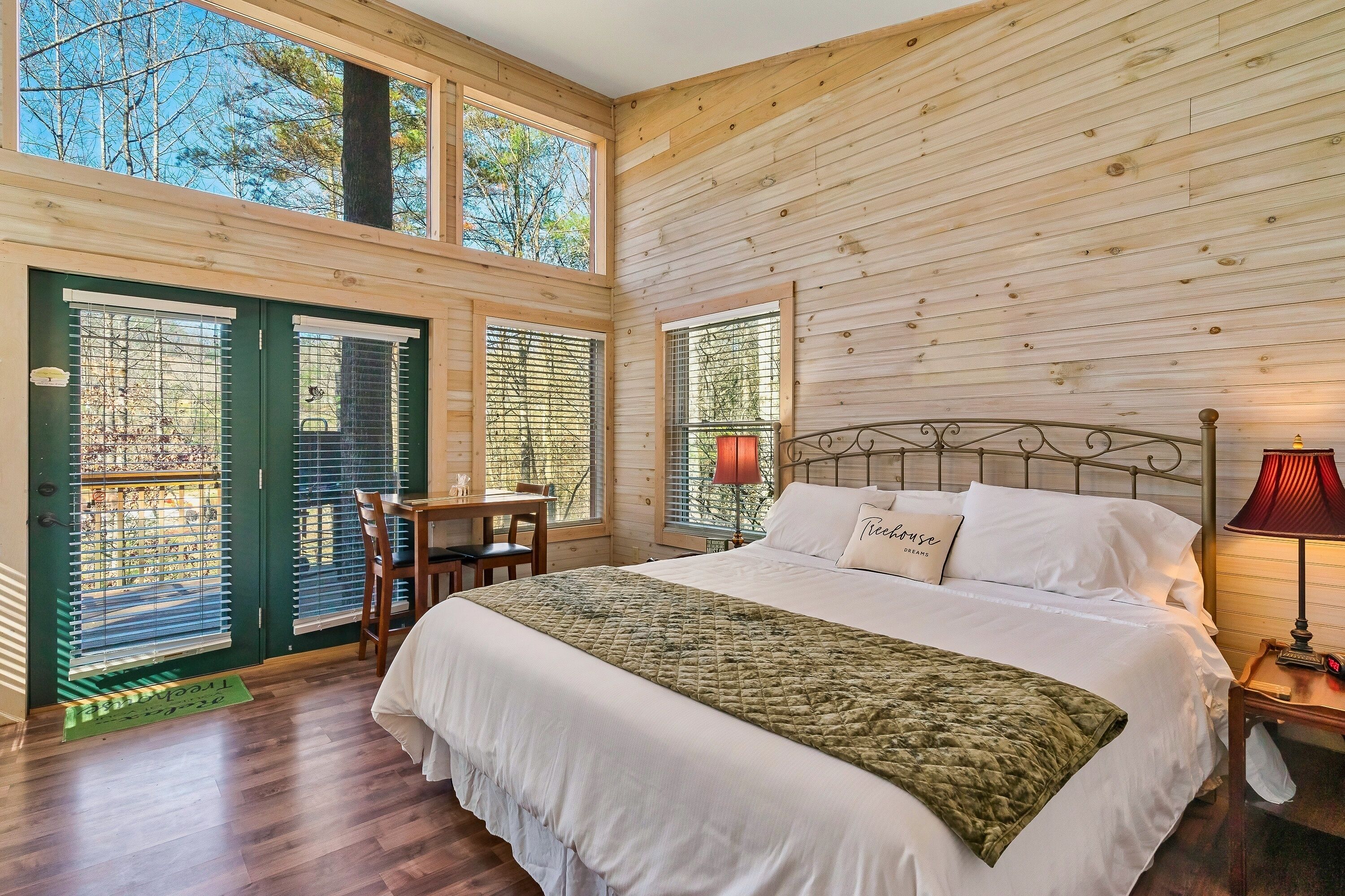 Un dormitorio con paneles de madera, una cama grande, un escritorio y una silla.