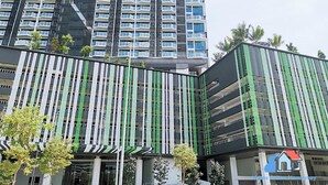 A modern building with a curved facade and vertical green stripes. - Almas Suites Puteri Harbour (Iskandar Puteri)