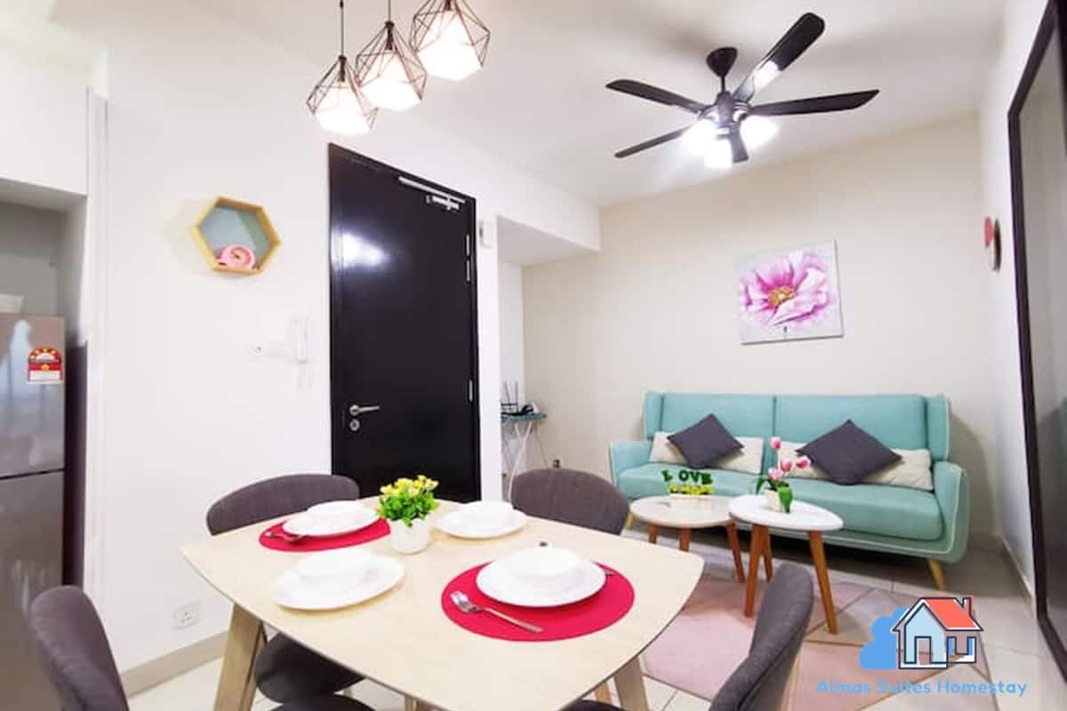 A compact living space with a dining area, a sofa, and a ceiling fan.