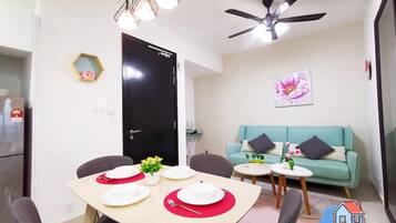 Un espacio habitable compacto con comedor, sofá y ventilador de techo.