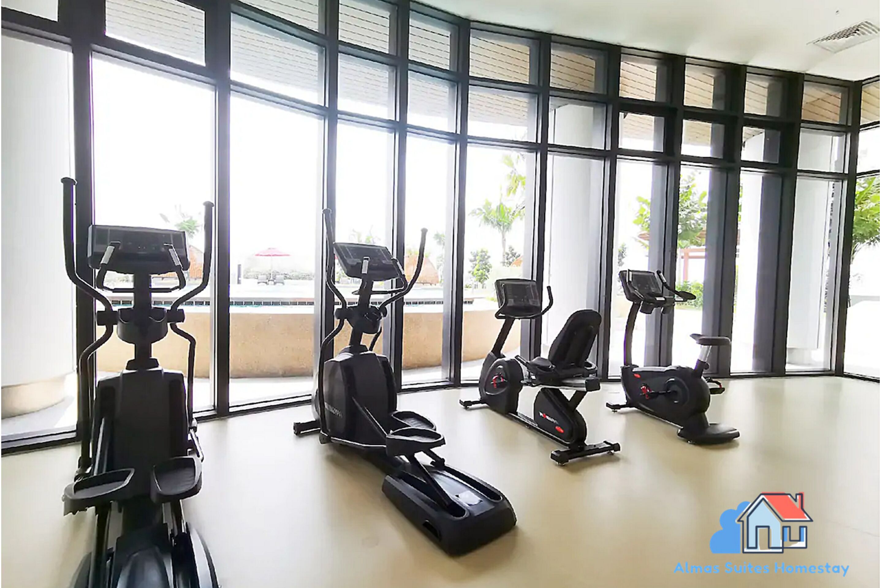 A gym with four stationary bikes and large windows.