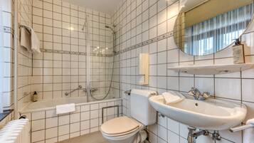 Ein modernes Badezimmer mit Badewanne, Toilette und Waschbecken.